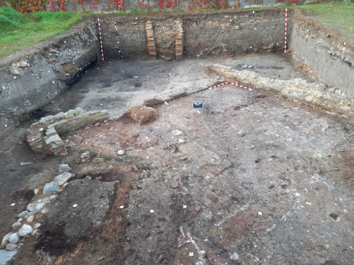 Clădirea romană II, camera W2: imagine de ansamblu cu detalii în prim plan ale unor pereți de lemn delimitați de tencuială și de tegulae mammatae, care configurează existența altor două canale de hypocaust (?) (vedere dinspre N).